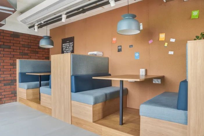 Flexible Arbeitsnischen mit gepolsterten Sitzbänken für konzentrierte Gespräche und kurze Meetings